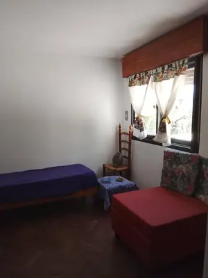 a bedroom with a bed and a couch and a window at Casita in Cordoba