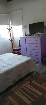 a bedroom with a purple dresser and a bed at Casa Sol Naciente in Villa Santa Cruz del Lago
