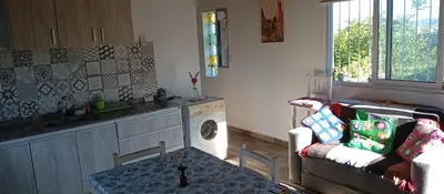 a kitchen with a living room with a couch and a table at Casa Sol Naciente in Villa Santa Cruz del Lago