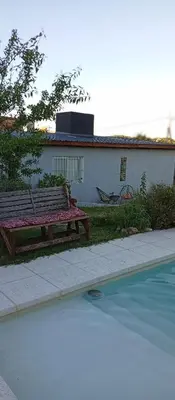 a wooden bench sitting next to a swimming pool at Casa Sol Naciente in Villa Santa Cruz del Lago