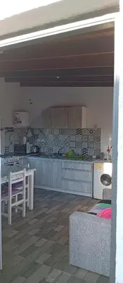 a kitchen with a table and a counter top at Casa Sol Naciente in Villa Santa Cruz del Lago