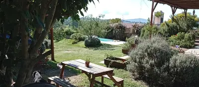 a garden with a wooden picnic table and a pool at Casa Sol Naciente in Villa Santa Cruz del Lago