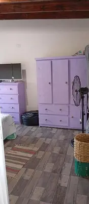 a bedroom with purple dressers and a fan at Casa Sol Naciente in Villa Santa Cruz del Lago