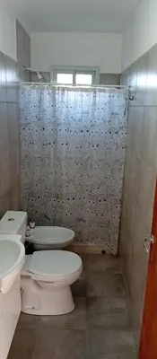a bathroom with a toilet and a shower curtain at Casa Sol Naciente in Villa Santa Cruz del Lago