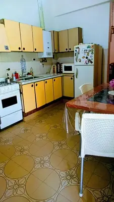 a kitchen with yellow cabinets and a white refrigerator at Casa Santa Rosa de Calamuchita in Santa Rosa de Calamuchita