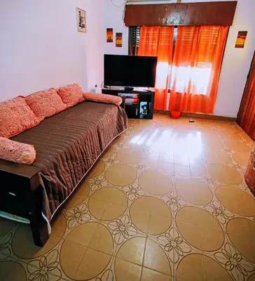 a living room with a bed and a flat screen tv at Casa Santa Rosa de Calamuchita in Santa Rosa de Calamuchita