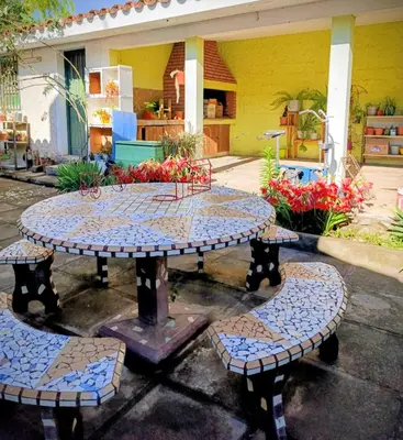 a table with two benches and a table with flowers at Casa Santa Rosa de Calamuchita in Santa Rosa de Calamuchita