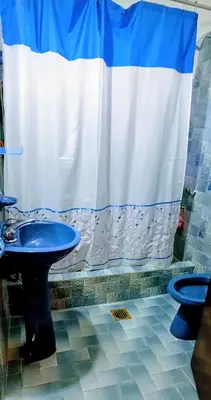 a bathroom with a blue sink and a shower curtain at Casa Santa Rosa de Calamuchita in Santa Rosa de Calamuchita