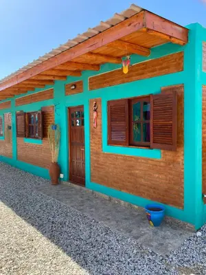 a house with a green facade and wooden windows at Alojamientos La Clarita in Arroyo de Los Patos