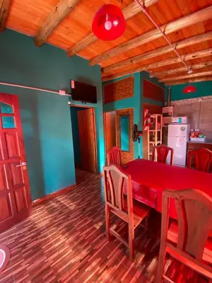 a dining room with a red table and chairs at Alojamientos La Clarita in Arroyo de Los Patos