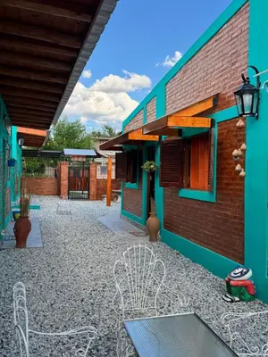 a courtyard of a building with a bench and chairs at Alojamientos La Clarita in Arroyo de Los Patos