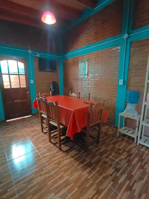 a dining room with a red table and chairs at Alojamientos La Clarita in Arroyo de Los Patos