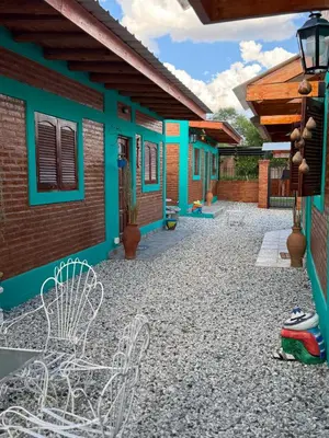 a house with blue and green walls and a patio at Alojamientos La Clarita in Arroyo de Los Patos