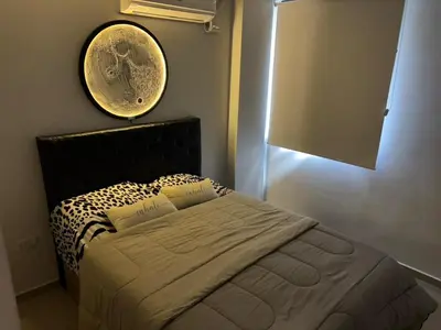 a bedroom with a bed with a clock on the wall at Calma Urbana in Cordoba