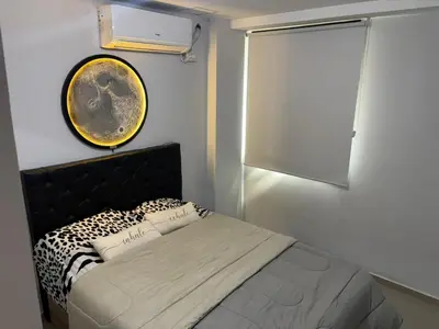 a bedroom with a bed with a cheetah blanket and a clock at Calma Urbana in Cordoba