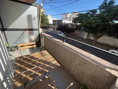 a wooden bench sitting on the side of a building at Calma Urbana in Cordoba