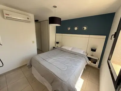 a bedroom with a bed and a blue wall at Departamento Jacinto en Córdoba in Cordoba