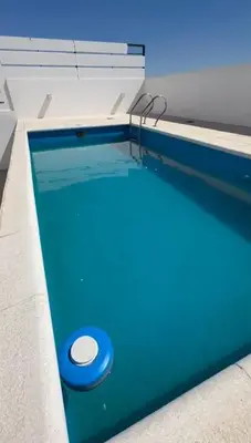 a swimming pool with a blue pool at Departamento Jacinto en Córdoba in Cordoba