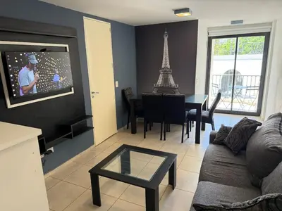 a living room with a couch and a tv with the eiffel tower at Departamento Jacinto en Córdoba in Cordoba