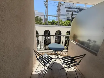 a balcony with a blue table and chairs on it at Departamento Jacinto en Córdoba in Cordoba
