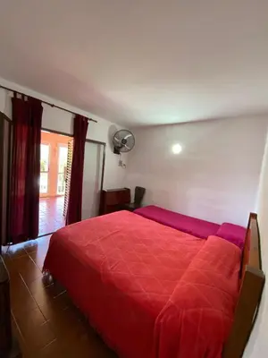 a bedroom with a red bed with a red blanket at Bendecida in San Antonio de Arredondo