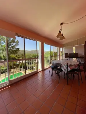 a dining room with a table and chairs and windows at Bendecida in San Antonio de Arredondo