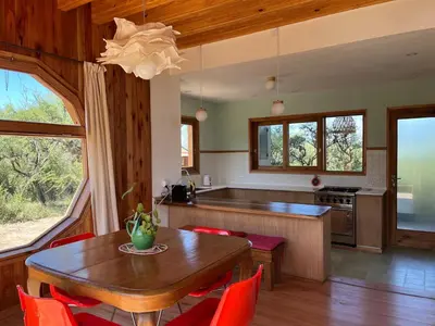 a kitchen with a wooden table and red chairs at Casa Estudio Japandi in San Javier