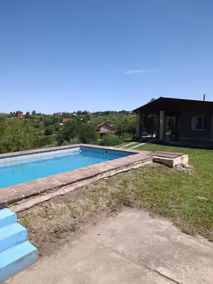 a swimming pool in a yard with a house at Pacha Samay in Villa Parque Siquiman