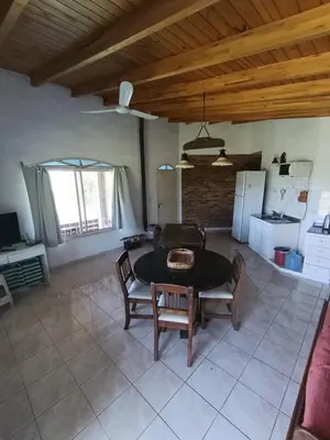 a living room with a table and a kitchen at Pacha Samay in Villa Parque Siquiman