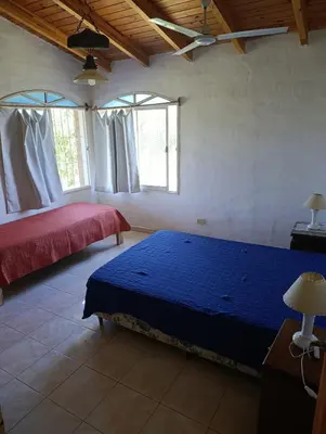 a bedroom with two beds and two windows at Pacha Samay in Villa Parque Siquiman