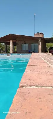 a swimming pool with blue water in front of a building at Pacha Samay in Villa Parque Siquiman