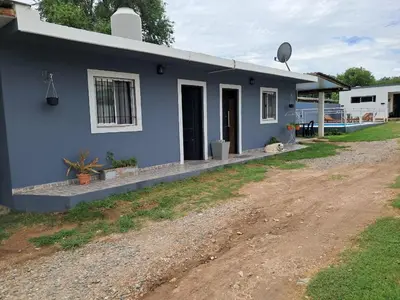 a blue house with a dirt road in front of it at Adonay in Mina Clavero