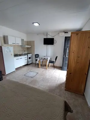a kitchen and dining room with a table and a kitchen with a refrigerator at Adonay in Mina Clavero