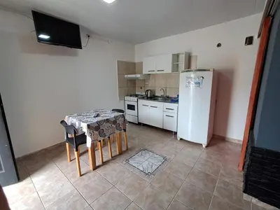 a kitchen with a small table and a refrigerator at Adonay in Mina Clavero