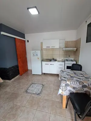 a small kitchen with two beds and a refrigerator at Adonay in Mina Clavero