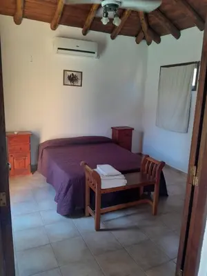 a bedroom with a bed and a wooden table at Cabañas La Bahia Escondida in Potrero de Garay
