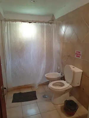a bathroom with a toilet and a shower curtain at Cabañas La Bahia Escondida in Potrero de Garay