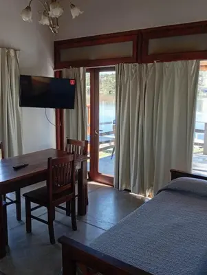 a bedroom with a bed and a desk and a television at Cabañas La Bahia Escondida in Potrero de Garay
