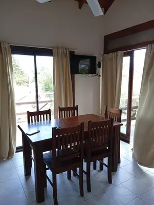 a dining room with a wooden table and chairs at Cabañas La Bahia Escondida in Potrero de Garay