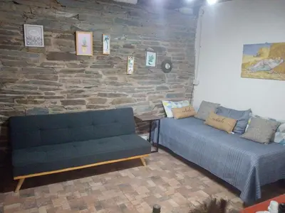 a living room with a couch and a brick wall at Espacio de relax in Trapiche