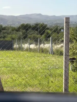a barbed wire fence with a field of grass at Can,19,Anisacate in Villa Anizacate