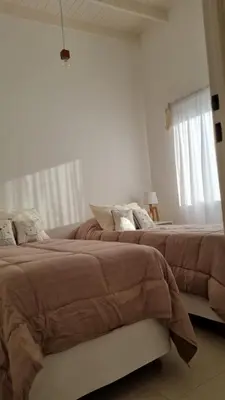 two beds in a bedroom with white walls at Cabañas NUEVA VIDA in Merlo