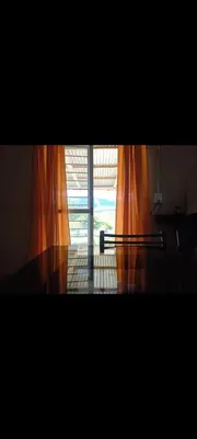 an open window with orange curtains in a room at Crespi in San Lorenzo