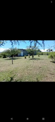 two photographs of a field with trees and a building at Crespi in San Lorenzo