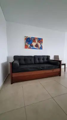 a black couch sitting against a white wall at Departamento a Pasos de la Terminal y Hospitales in Cordoba