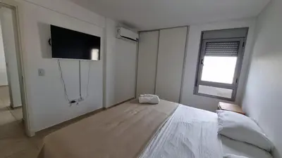 a bedroom with a bed and a flat screen tv at Departamento a Pasos de la Terminal y Hospitales in Cordoba