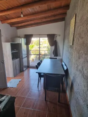 a dining room with a table and chairs at Departamento mina clavero in Mina Clavero