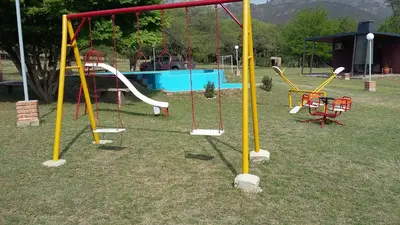 a park with a playground with slides and swings at Cabañas Viena II cerquita de Villa General Belgrano in Villa Ciudad Parque