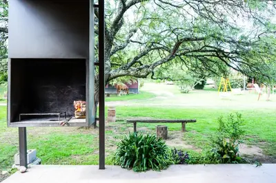 a park with a bench and a tree and a playground at Cabañas Viena II cerquita de Villa General Belgrano in Villa Ciudad Parque