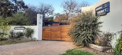 a gate to a house with a wooden fence at Cabañas Viena II cerquita de Villa General Belgrano in Villa Ciudad Parque